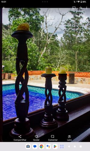 a group of vases sitting next to a swimming pool at Pousada Som de Lumiar in Lumiar