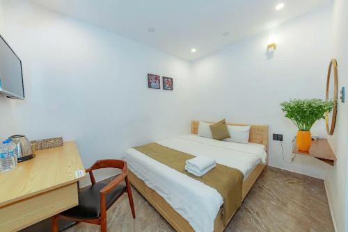 a bedroom with a bed and a desk with a computer at Sunrise Valley Dalat Hotel in Da Lat