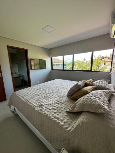 a bedroom with a large bed with pillows on it at House 16 - Reserva dos Carneiros in Tamandaré