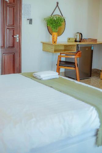 a bed in a room with a table and a chair at Sunrise Valley Dalat Hotel in Da Lat