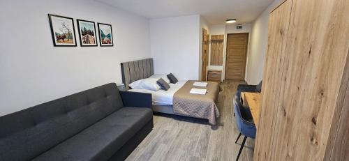 a living room with a couch and a bed at Rewita Kościelisko-Zakopane in Kościelisko