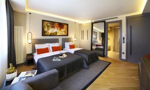 a hotel room with two beds and a couch at The Capital Hotel in Istanbul