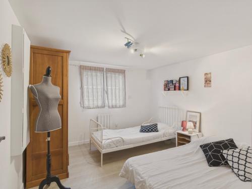 - une chambre avec deux lits et un mannequin dans l'établissement Maison 8 personnes avec grand jardin - Beg Meil, à Fouesnant