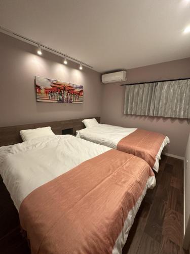 two beds in a hotel room with at Cottage in Tokashiki MIUFUYA in Tokashiki