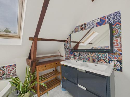 une salle de bain avec un lavabo et un miroir dans l'établissement Maison 8 personnes avec grand jardin - Beg Meil, à Fouesnant