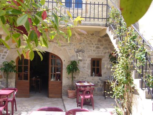 a patio with tables and chairs in a building at Hotel Des Arts in Puybrun