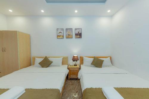 two beds sitting next to each other in a room at Sunrise Valley Dalat Hotel in Da Lat