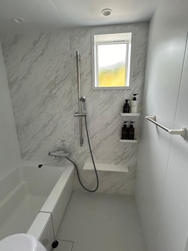 a bathroom with a shower and a tub and a sink at Cottage in Tokashiki MIUFUYA in Tokashiki