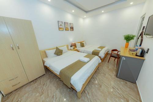a hotel room with two beds and a desk at Sunrise Valley Dalat Hotel in Da Lat