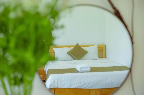 a reflection of a bed in a mirror at Sunrise Valley Dalat Hotel in Da Lat
