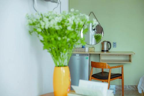 an orange vase with white flowers on a table at Sunrise Valley Dalat Hotel in Da Lat