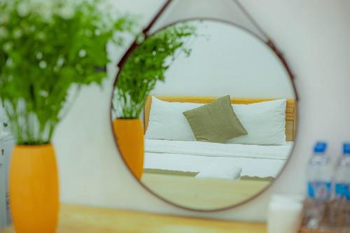 a mirror on a table with a couch and two vases at Sunrise Valley Dalat Hotel in Da Lat