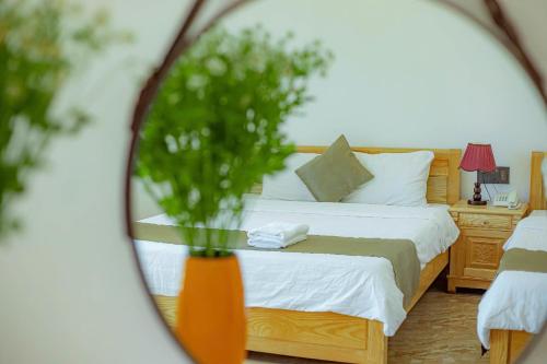 a bedroom with a bed with a vase of flowers at Sunrise Valley Dalat Hotel in Da Lat