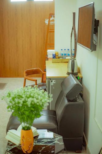 a office with a chair and a desk with a plant at Sunrise Valley Dalat Hotel in Da Lat