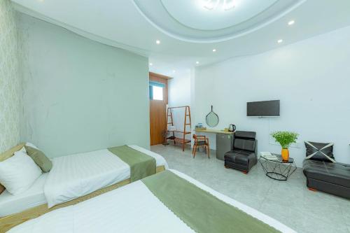 a hotel room with two beds and a television at Sunrise Valley Dalat Hotel in Da Lat