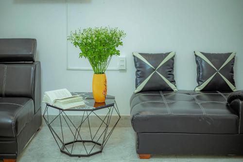 a living room with a couch and a table with a vase at Sunrise Valley Dalat Hotel in Da Lat