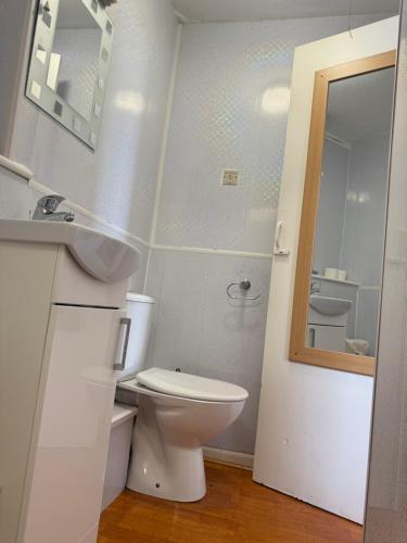 a bathroom with a toilet and a sink and a mirror at The Aberford in Blackpool