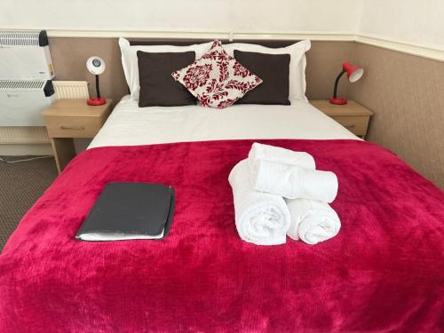 a bed with towels and a laptop on it at The Aberford in Blackpool