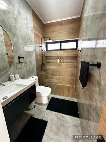 a bathroom with a sink and a toilet and a mirror at Stunning Brand New Villa in Downtown Punta Cana in Punta Cana