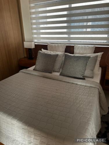 a bedroom with a large bed with pillows and a window at Stunning Brand New Villa in Downtown Punta Cana in Punta Cana
