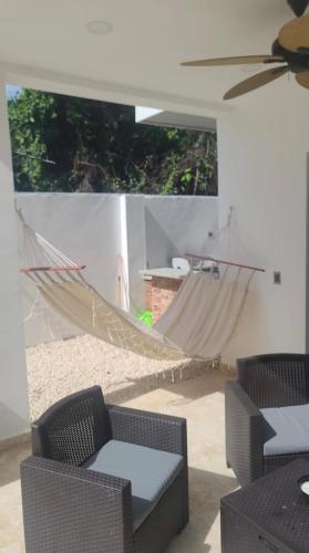 a patio with a hammock and a table and chairs at Stunning Brand New Villa in Downtown Punta Cana in Punta Cana