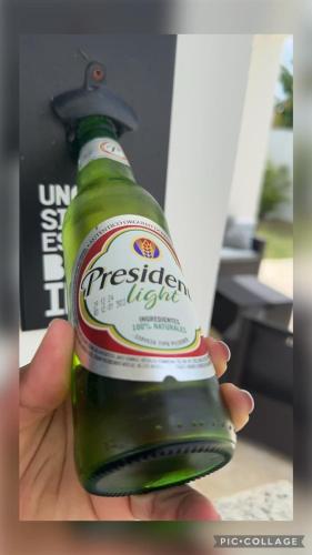 a person holding a green bottle of beer at Stunning Brand New Villa in Downtown Punta Cana in Punta Cana