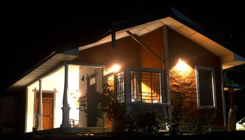 a house with lights on the side of it at night at Pelican View Cottages in Kataragama