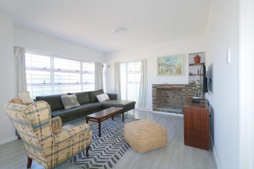 Una sala de estar con un sofá y una chimenea. en Royal House, en Muizenberg