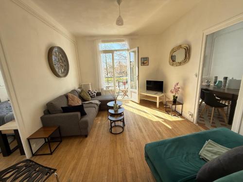 un salon avec un canapé et une table dans l'établissement L'Escale 32, au Mans