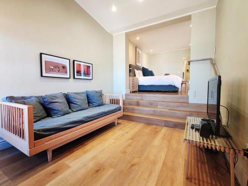 a living room with a couch and a bed at Sunrise Paradise Penthouse in Muizenberg
