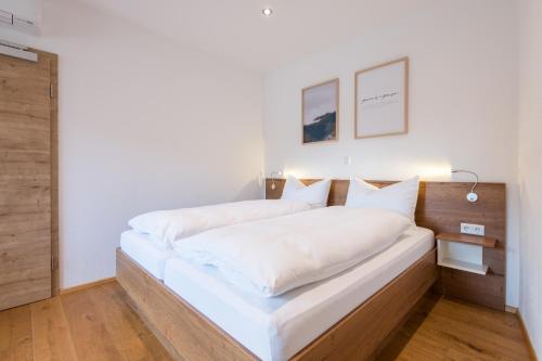 a bedroom with a large bed with white sheets at Pension Zum Schrammel in Altdorf bei Nuernberg