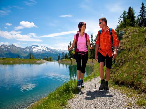 a man and a woman walking along a lake at Rainberghof***, Appartements in Rauris