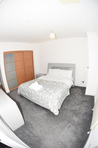 a bedroom with a bed in a white room at Glasgow Hydro Apt with Great Views in Glasgow