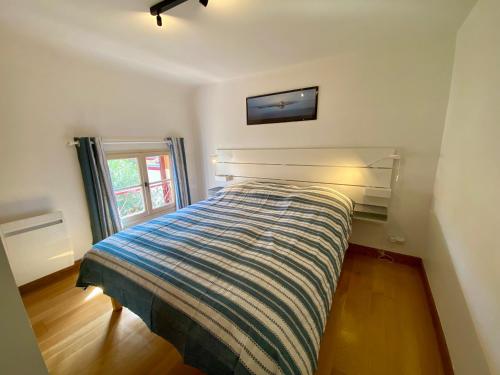 - une chambre avec un lit et une télévision murale dans l'établissement St THOMAS, à La Teste-de-Buch