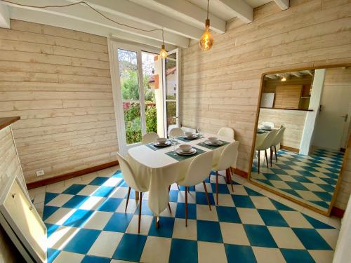 - une salle à manger avec une table et des chaises sur un sol en damier dans l'établissement St THOMAS, à La Teste-de-Buch