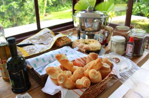 a table with a basket of pastries and bread at Pousada Som de Lumiar in Lumiar