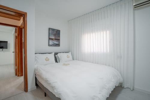 a white bedroom with a white bed and a window at Villa Yuka- Luxurious Villa in Eilat