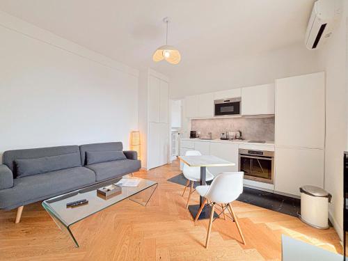 un salon avec un canapé bleu et une table dans l'établissement Escapade en centre ville de Nice - Wifi, AC, 2pers, à Nice