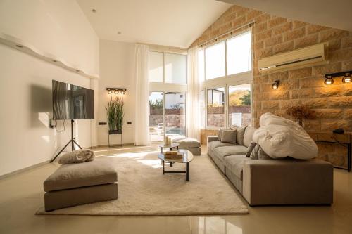 a living room with a couch and a tv at Villa Yuka- Luxurious Villa in Eilat
