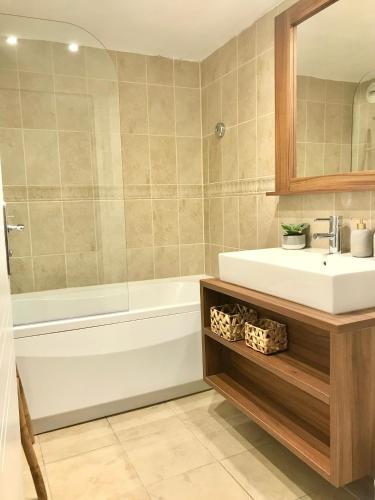 une salle de bain avec un lavabo, une baignoire et un miroir dans l'établissement Cosy 8-10pers vue montagne Isola 2000, à Isola