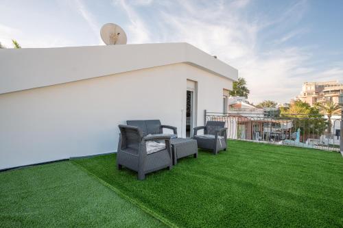 a patio with chairs and grass on a roof at Villa Yuka- Luxurious Villa in Eilat