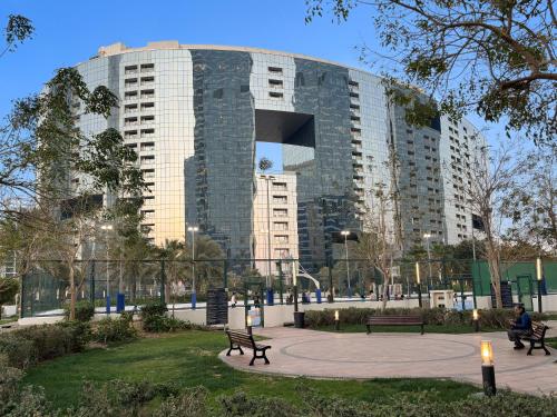 a building with a park with benches in front of it at Desert Key - Platinum Apartments in Gate Tower, Al Reem Island in Abu Dhabi