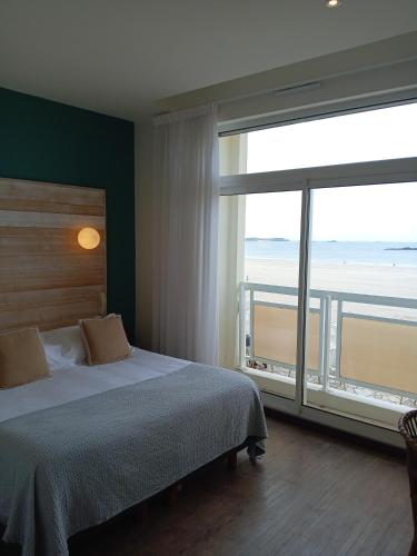 une chambre avec un lit et une grande fenêtre dans l'établissement Alba hotel, à Saint-Malo