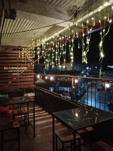 a dining room with tables and chairs and lights at Barnwood Homestay&cafe in Banaue