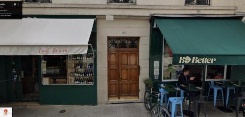 un magasin avec un auvent vert à côté d'un bâtiment dans l'établissement Charming studio in the Marais, à Paris