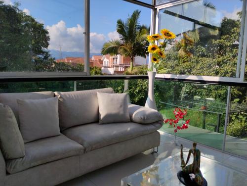 a living room with a couch and a vase with sunflowers at MonteClaro de Fusa in Fusagasuga
