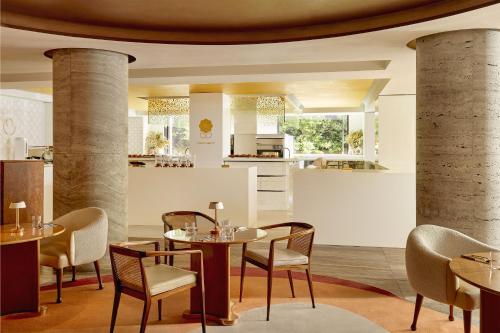 a restaurant with tables and chairs and a kitchen at The Berkeley, Maybourne in London