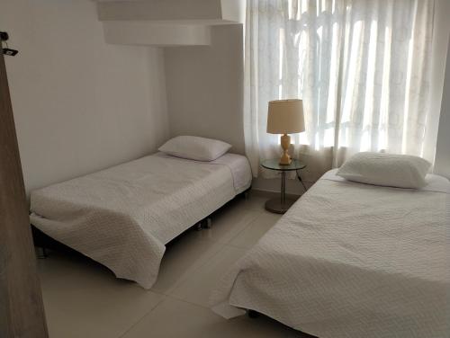 two beds in a small room with a window at MonteClaro de Fusa in Fusagasuga