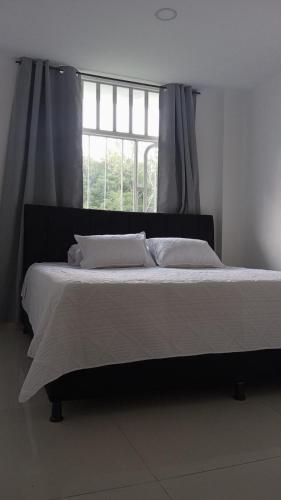 a bedroom with a large bed with a window at MonteClaro de Fusa in Fusagasuga