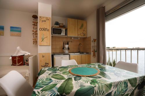 une cuisine avec une table avec une assiette dessus dans l'établissement St Cyprien charmant Studio proche de la marina, à Saint-Cyprien